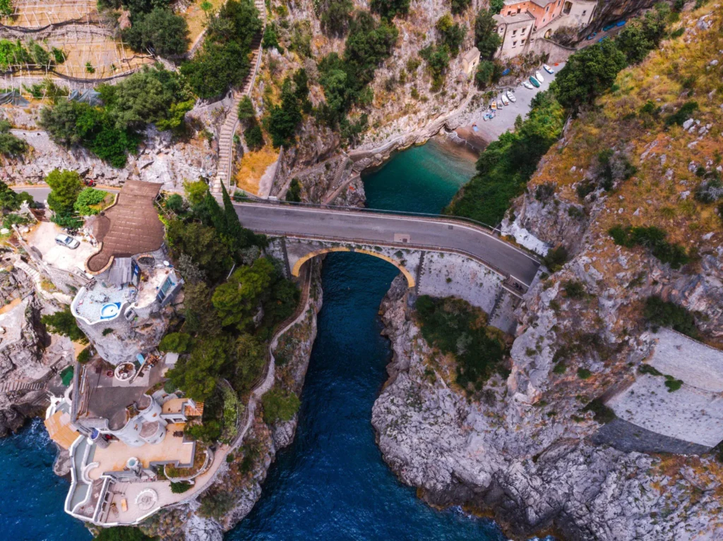 ```txt Fiordo di Furore hidden canyon on the Amalfi Coast with emerald water and stone bridge